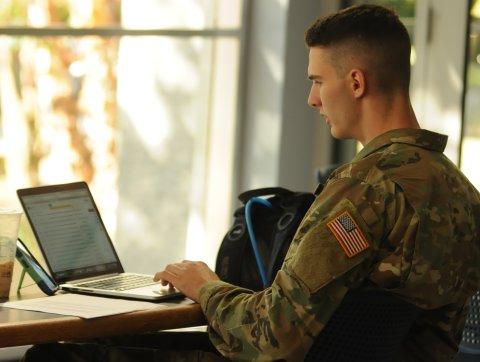 身着军装的学生在笔记本电脑上工作. 